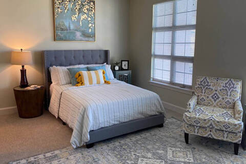 Bedroom with bed by windows.