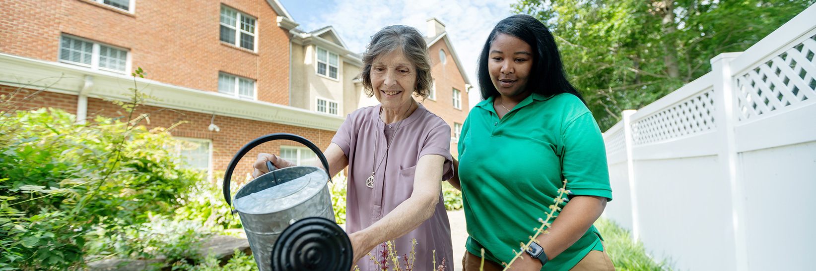 A resident and caregiver watering plants in the garden at Rockland Place in Wilmington, DE. A resident and caregiver watering plants in the garden at Rockland Place in Wilmington, DE.