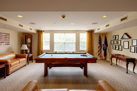 An activity room with a pool table.
