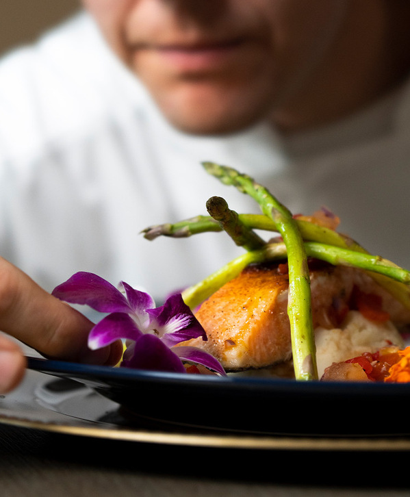 Accordion image A chef putting food on a plate.
