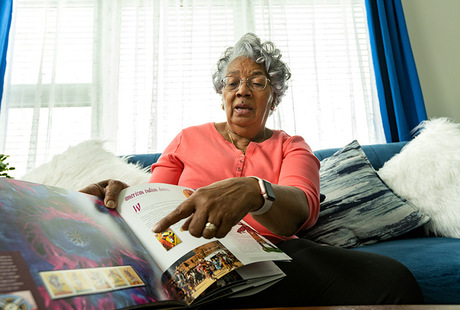 An independent living resident looking at a book.