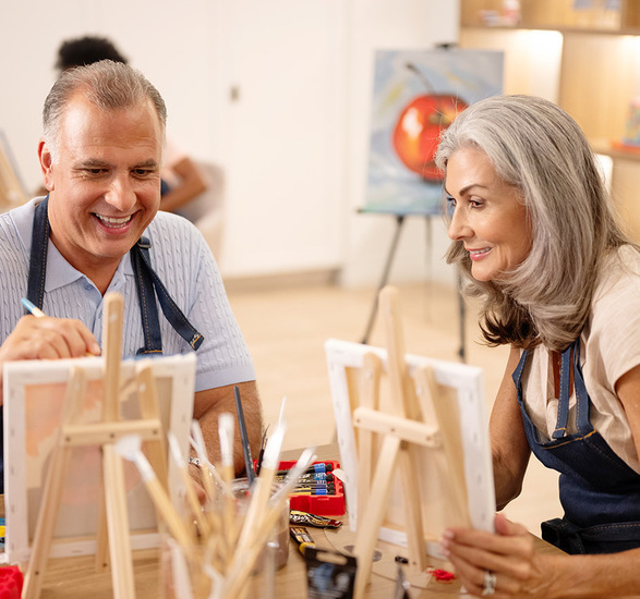 Two people painting in a class.