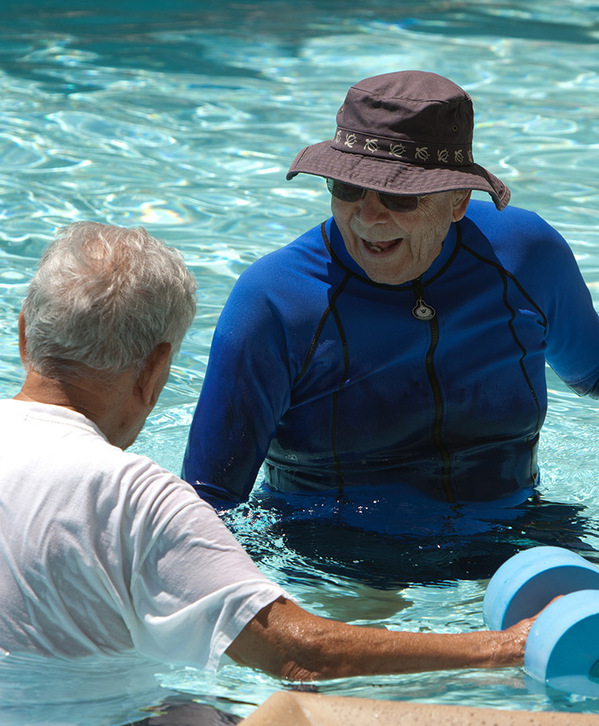 Move A resident is being assisted by a caregiver for water aerobics.