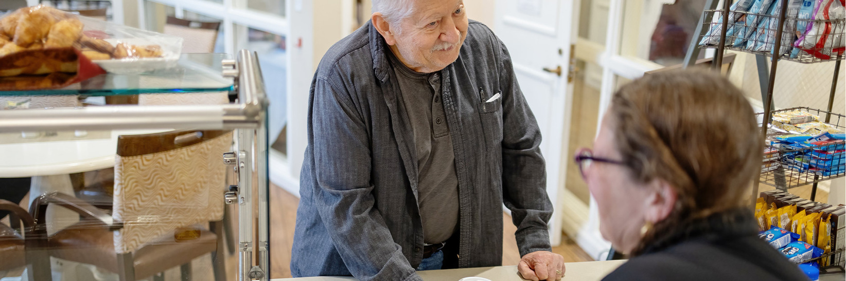 An independent living resident of the Fountains at Millbrook is buying coffee. An independent living resident of the Fountains at Millbrook is buying coffee.