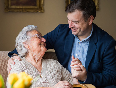 Two people looking at each other smiling.