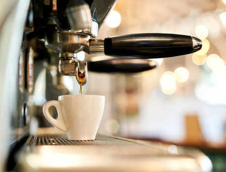 Coffee being poured by a espresso machine.