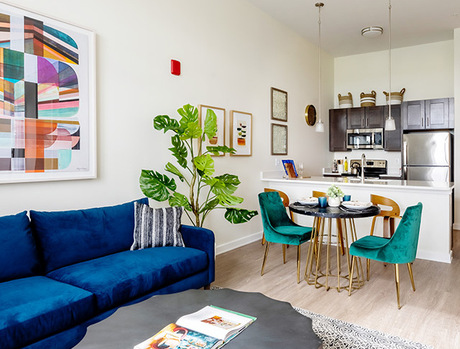 A fully furnished living room looking into the dining kitchen area.