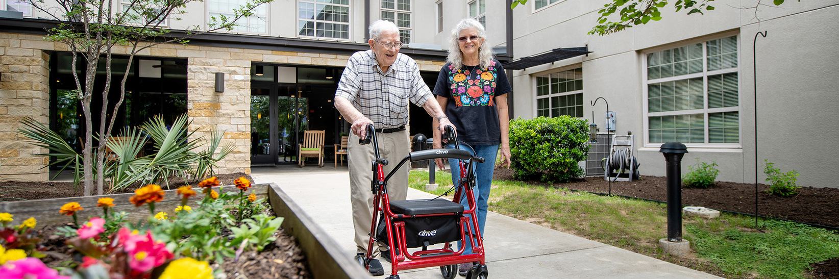 A resident and adult child walking in the garden. A resident and adult child walking in the garden.