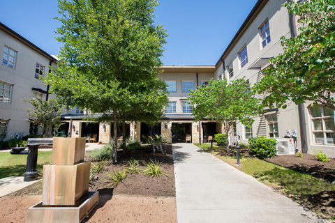 A garden with a fountain and walkway.