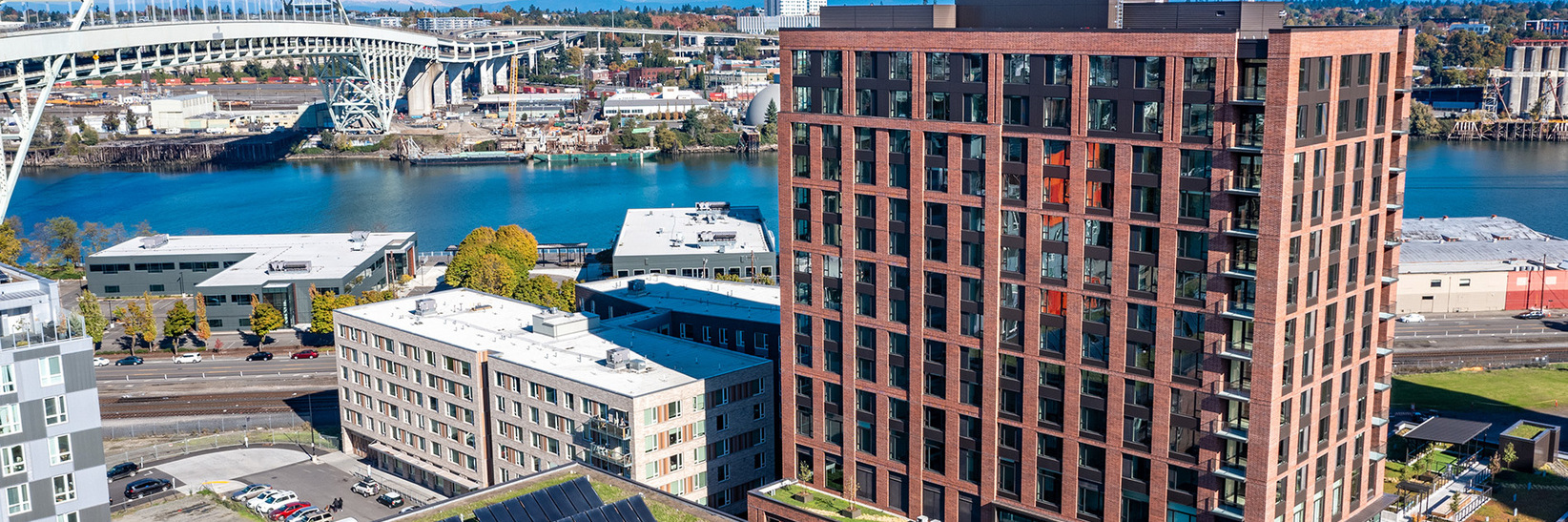 The building exterior with other buildings and a bridge in the back.