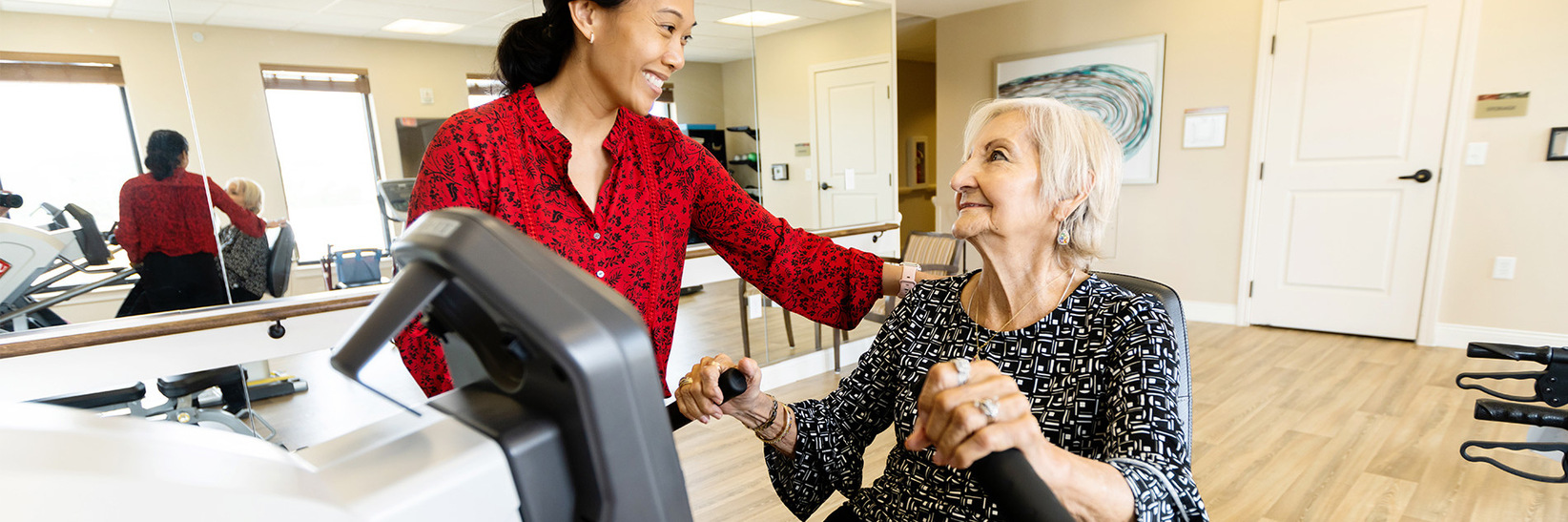 A person helping a resident work out. A person helping a resident work out.