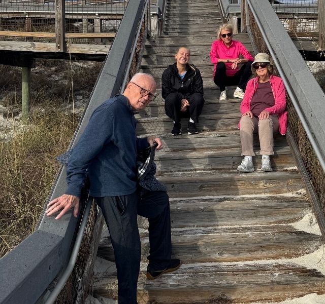 Residents in a walking club at a beach.
