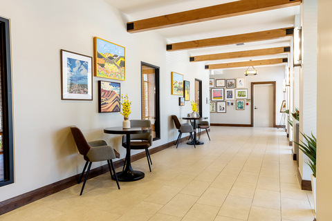A corridor with art on the walls and seating.