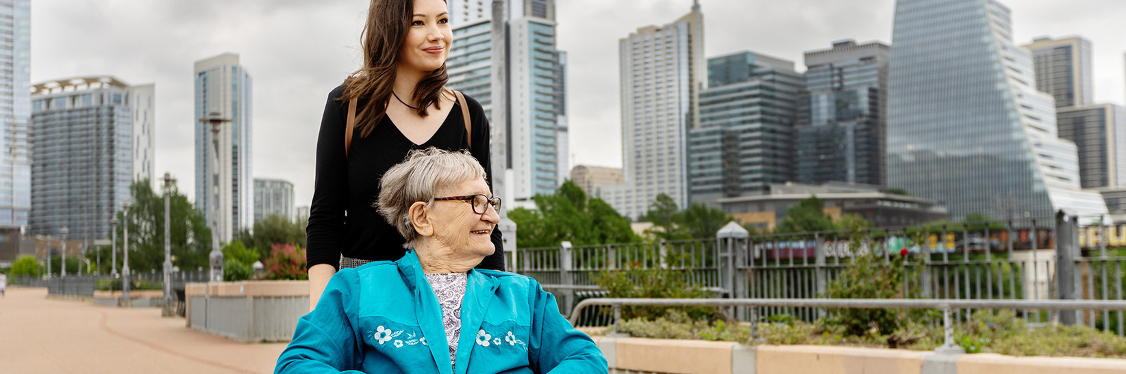 A caregiver with a resident on a walking path on a bridge at The Watermark at Southpark Meadows, an assisted living community in Austin. A caregiver with a resident on a walking path on a bridge at The Watermark at Southpark Meadows, an assisted living community in Austin.