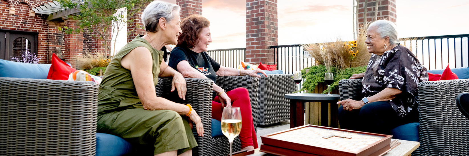 Three residents are sitting outside on the patio. Three residents are sitting outside on the patio.