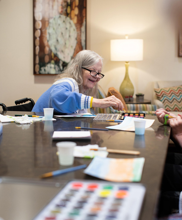 Accordion image Resident enjoying a painting activity.