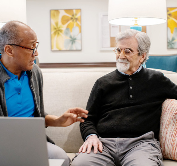 Two people discussing a computer.