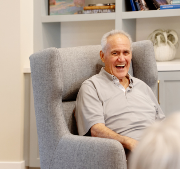 Happy resident sitting in chair.