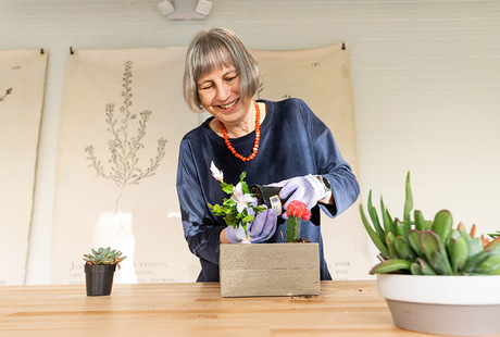 A person working in a greenhouse at The Watermark at Bellevue, a senior living community in Bellevue.
