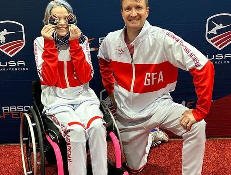 Cora is with her coach at the Paralympics.