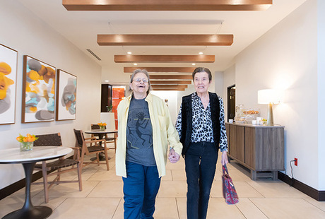 Two residents walking down a hallway.