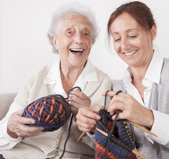 Two people with knitting yarn.