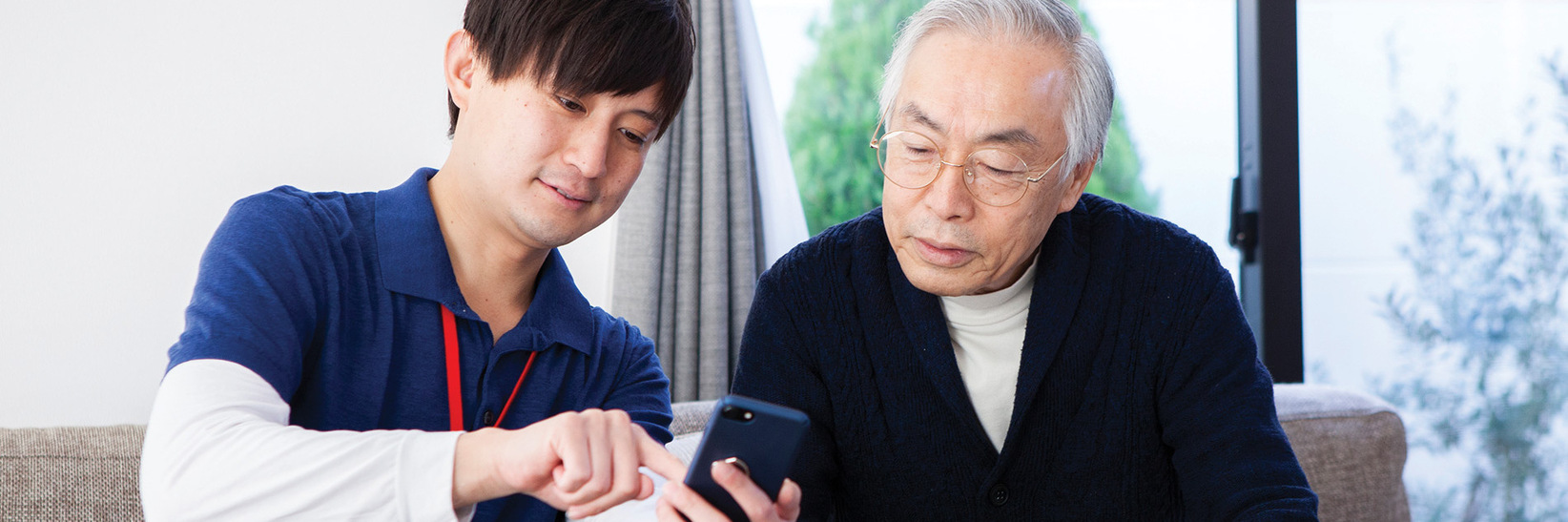 A resident is having tech concierge show them a new phone. A resident is having tech concierge show them a new phone.
