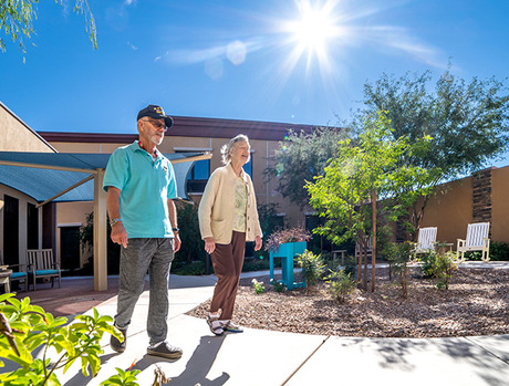 two residents walking outside on sidewalk pathways