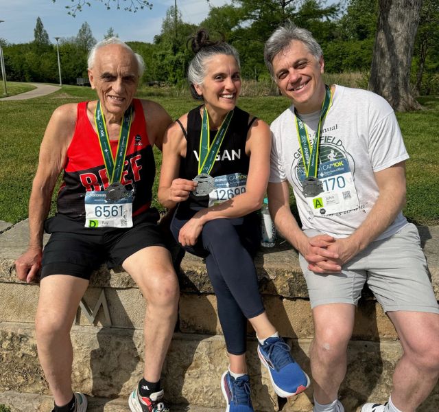 Resident wearing race medal with the two other winners.
