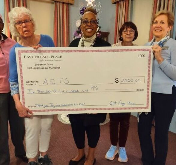 Five people holding large check donation for $2,500.