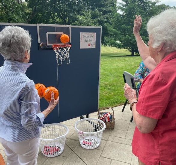 Residents throwing small basketballs into a net.