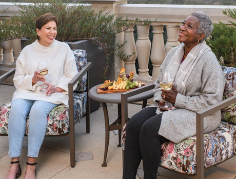 Residents sitting out in the patio by a fire.