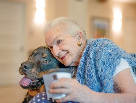 A resident hugging their dog.