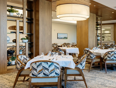 A dining room with tables set for dinner.