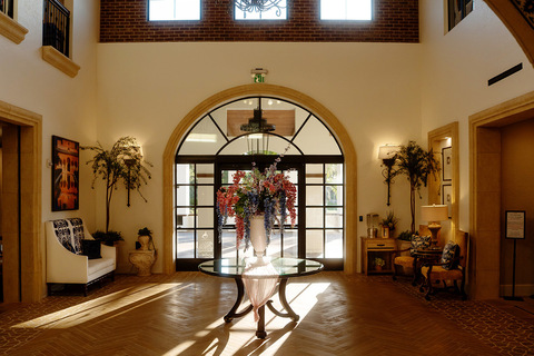 The entrance doors with a table and large floral arrangement.