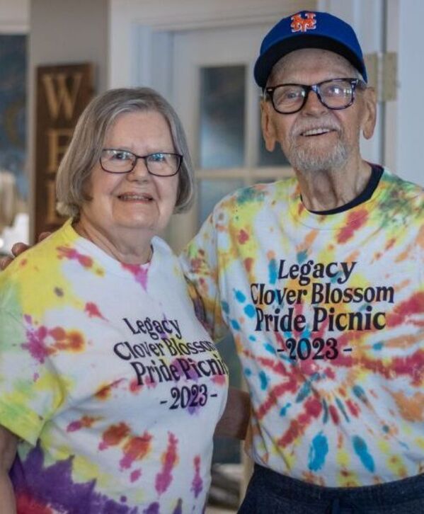Accordion image Two people wearing tie-dyed Pride shirts.
