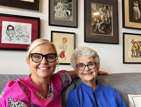 Daughter and Mom smiling and sitting on couch.