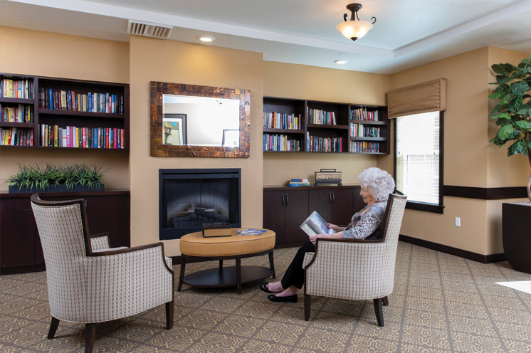 A resident reading in front of a fireplace.