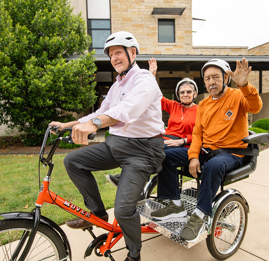 An associate giving two residents a ride on the thricycle.