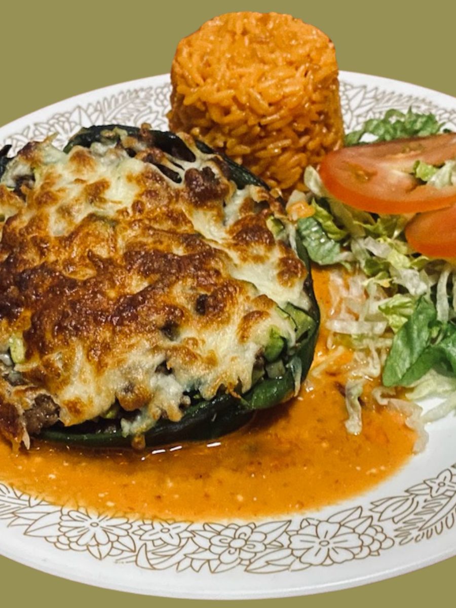 A stuffed Poblano Chile Pepper with rice and salad on the side.