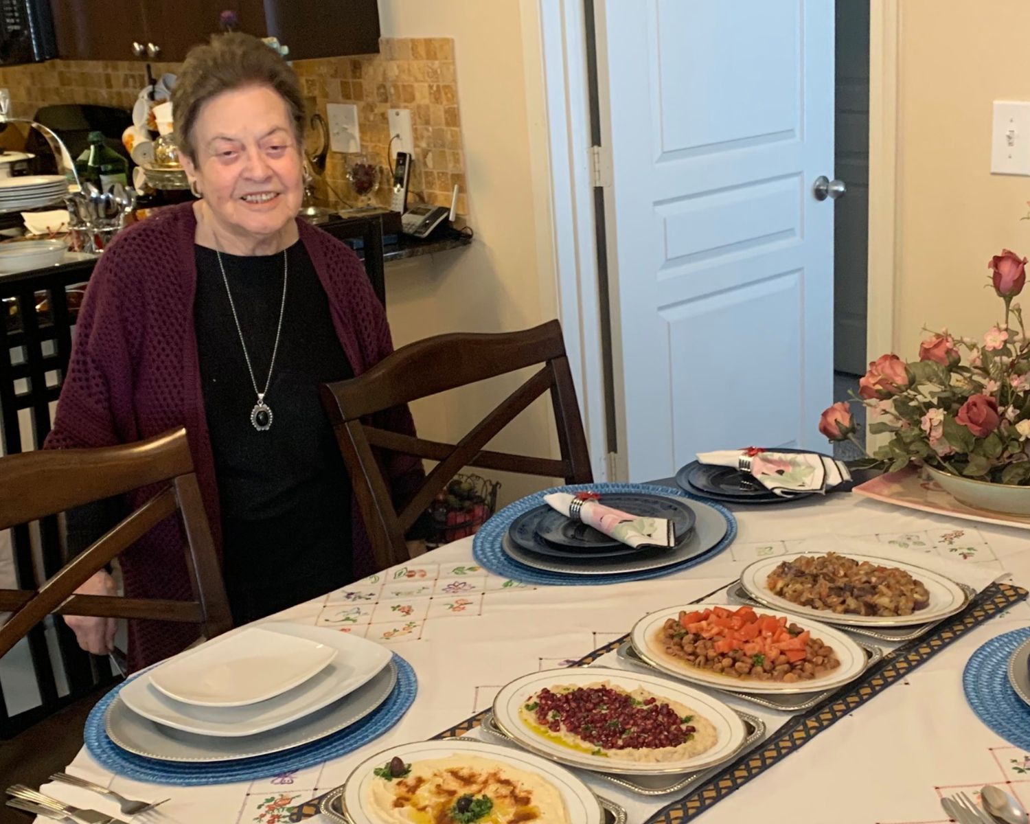 Suad, a resident, standing next a meal she prepared.
