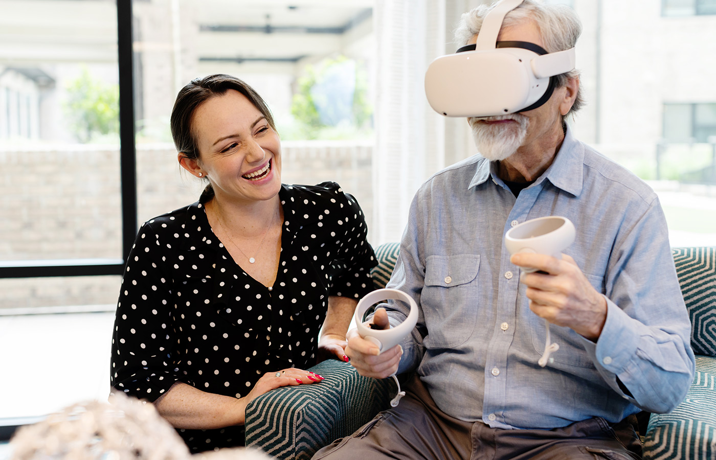 A naya caregiver helping a resident with a VR headset.