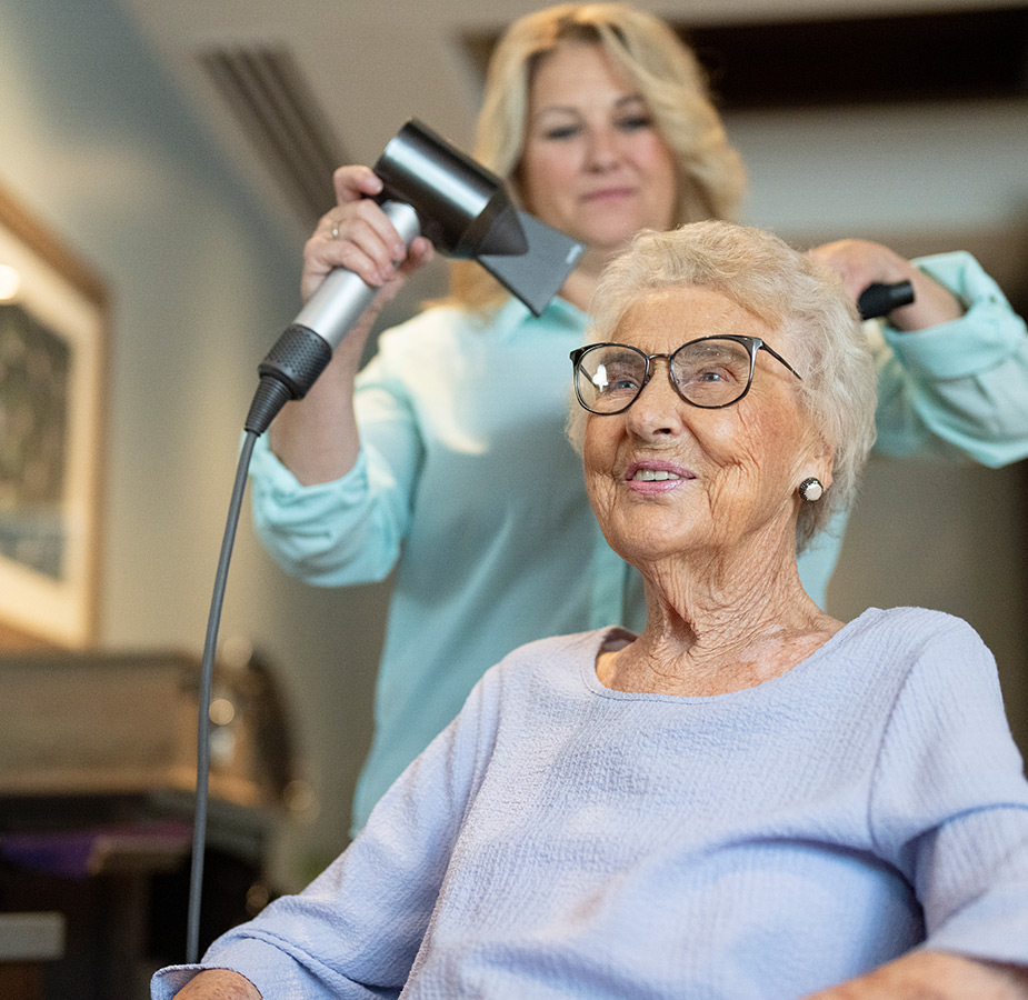 A resident is having their hair styled at the salon.