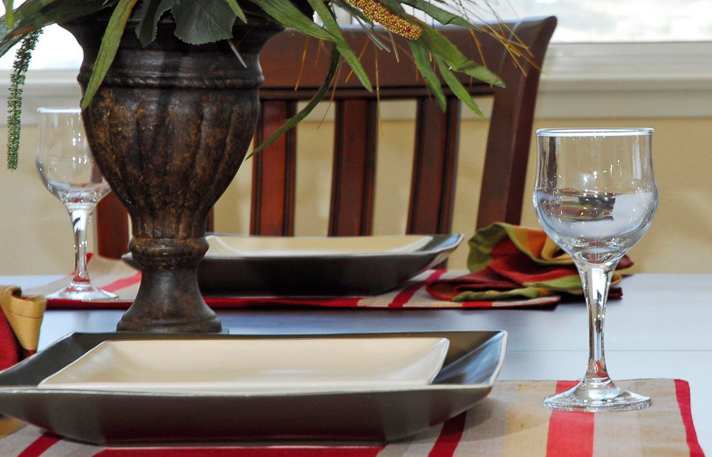 Dining room table set with plates and glasses.