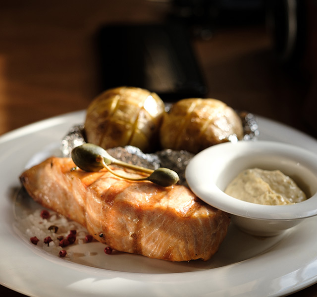 A plate with salmon and vegetables.
