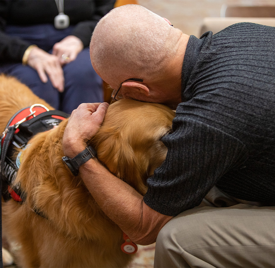 A person hugging a dog.