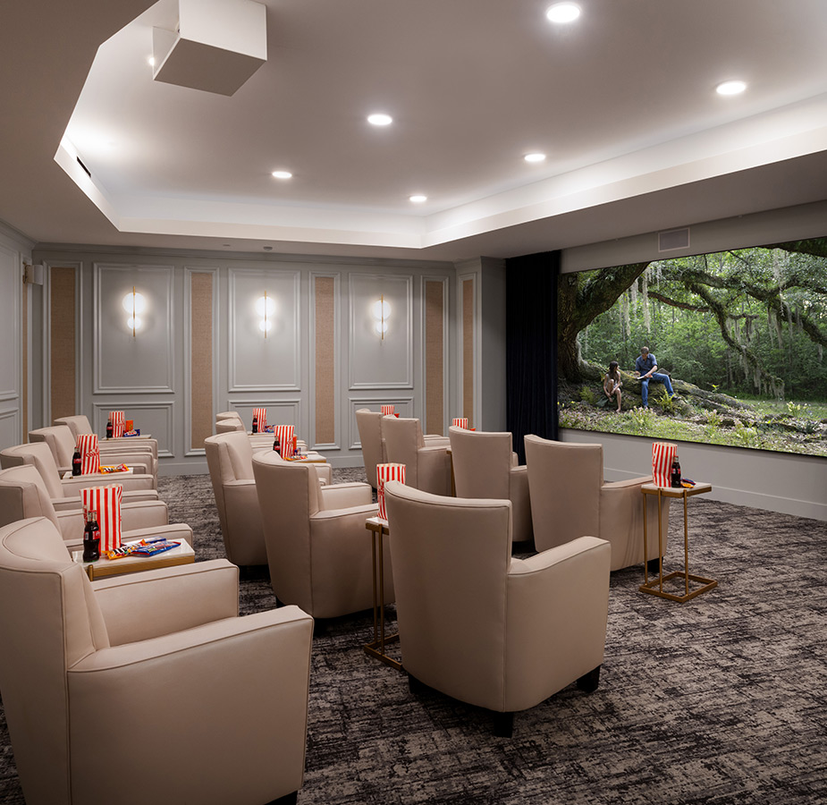 A theater room with big comfy chairs and a large screen.