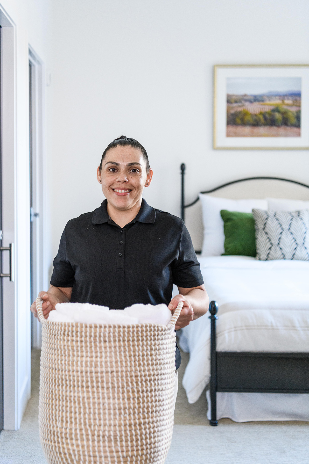 Housekeeping with woman picking up laundry.