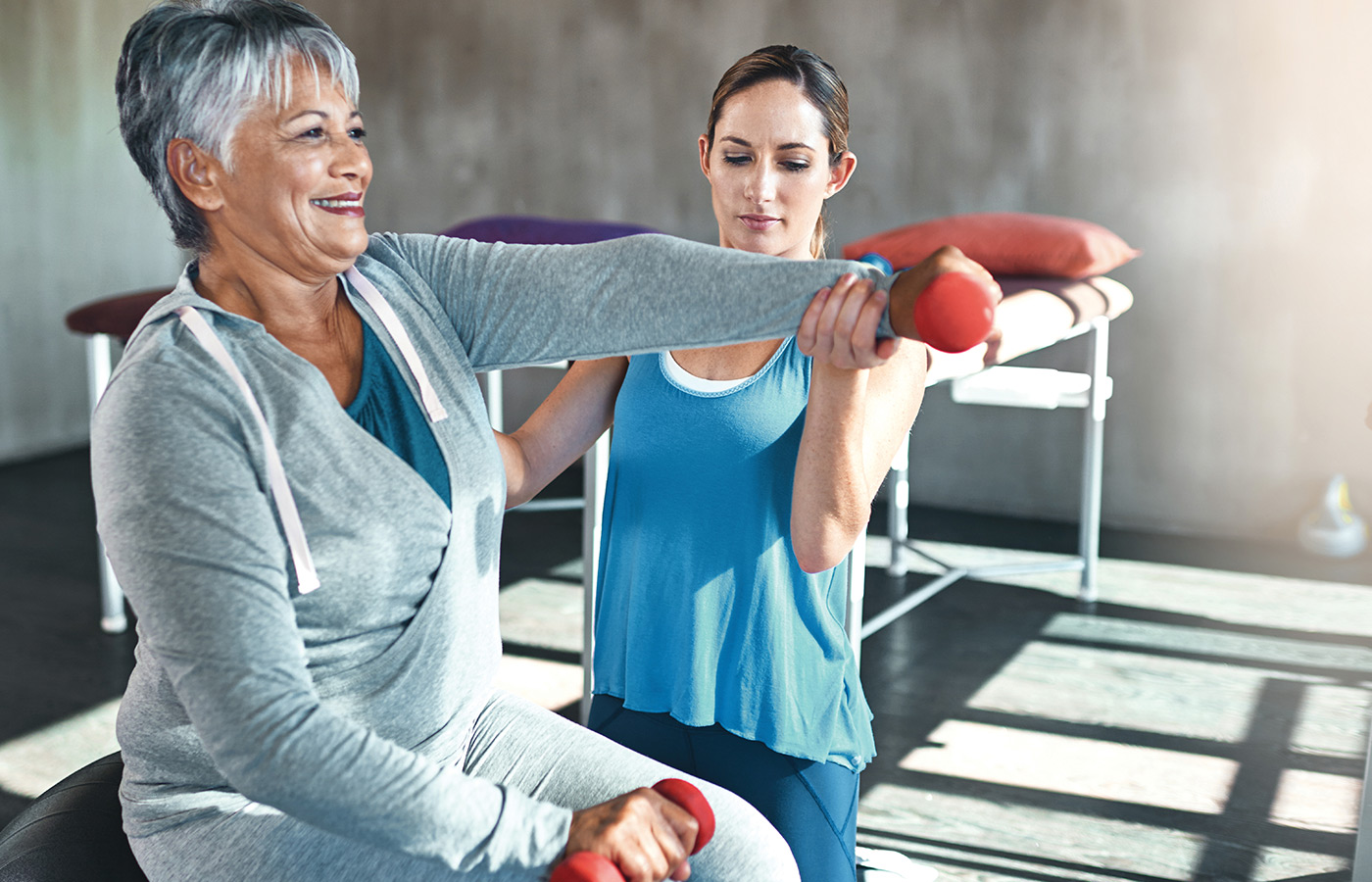 An associate assisting a resident in a fitness class