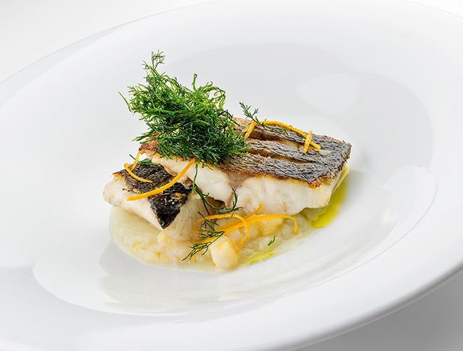 Grilled sea bass on a plate.